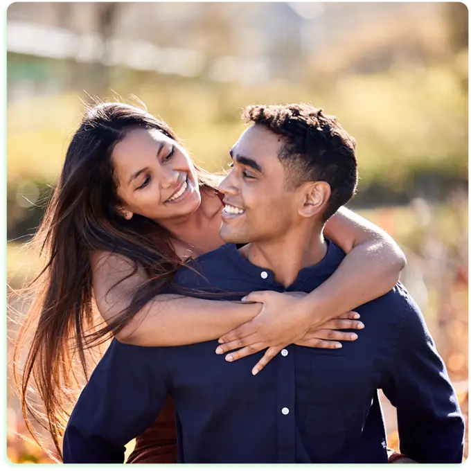 Casal feliz, abraçado, no campo. Transformação no Relacionamento em perfeita harmonia.